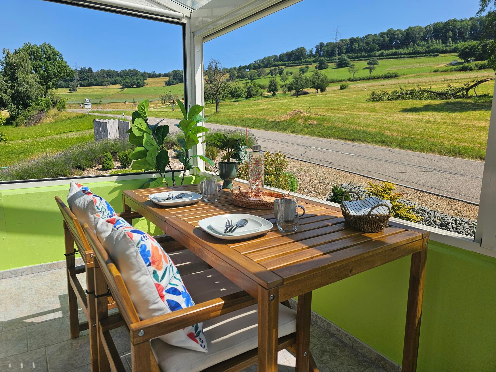 Panorama-Wintergarten mit gedecktem Tisch und Blick auf die Weinberge
